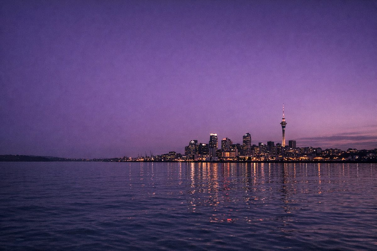 Auckland city skyline and the Sky Tower at dusk, seen from across the water